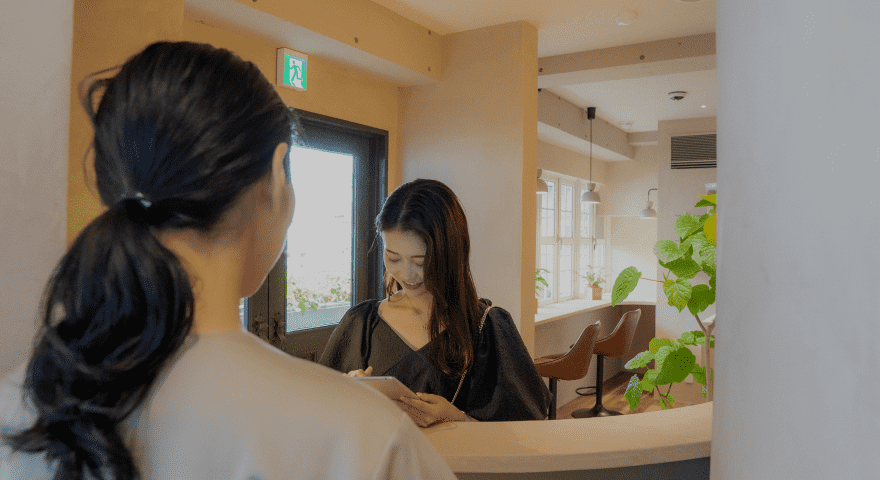 『すみっこ』の文字と壁の間接照明が柔らかい雰囲気を演出するサロンの一角