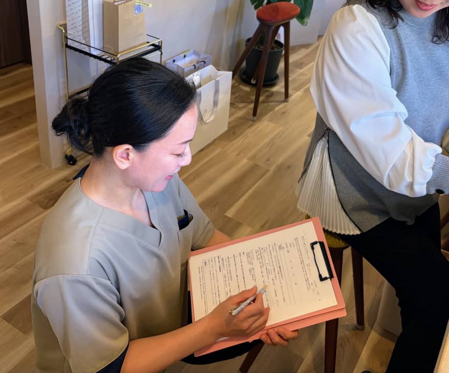 スタッフが問診票を見ながら来店者に説明をしているカウンセリングの様子