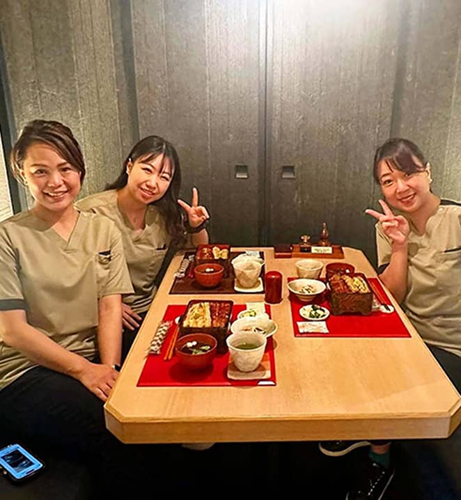 ベージュの制服を着た「すみっこ」スタッフの集合写真